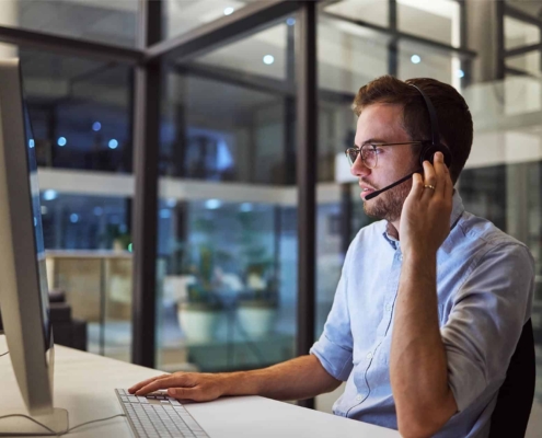 Image-of-a-business-person-using-a-computer-while-talking-over-a-headset.