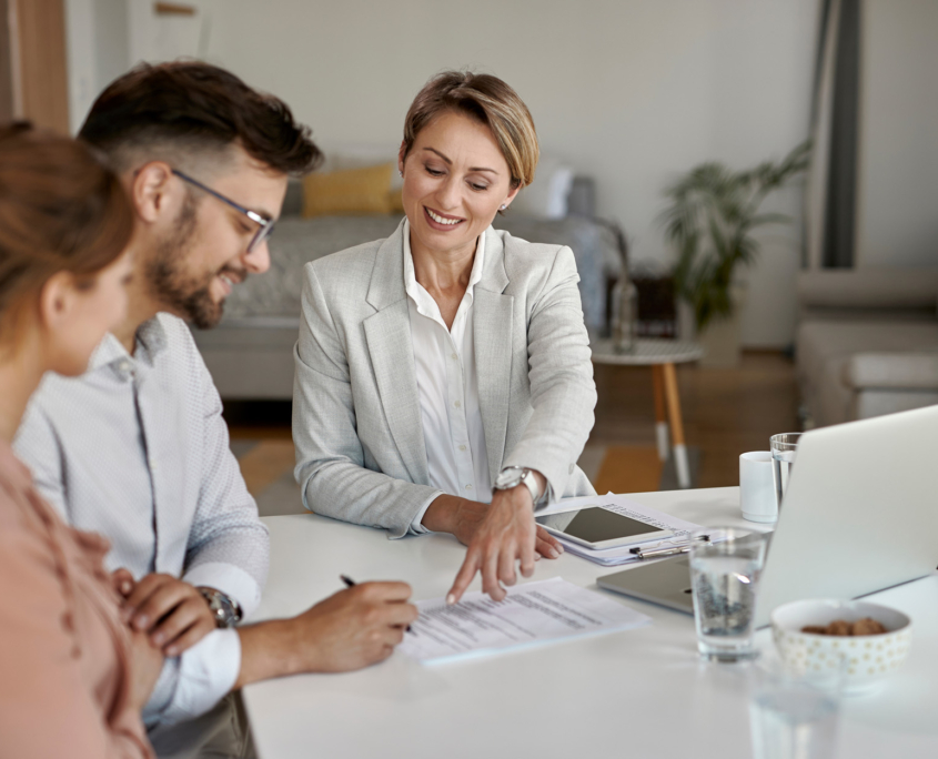 real estate agent showing to a couple where to sign the contract