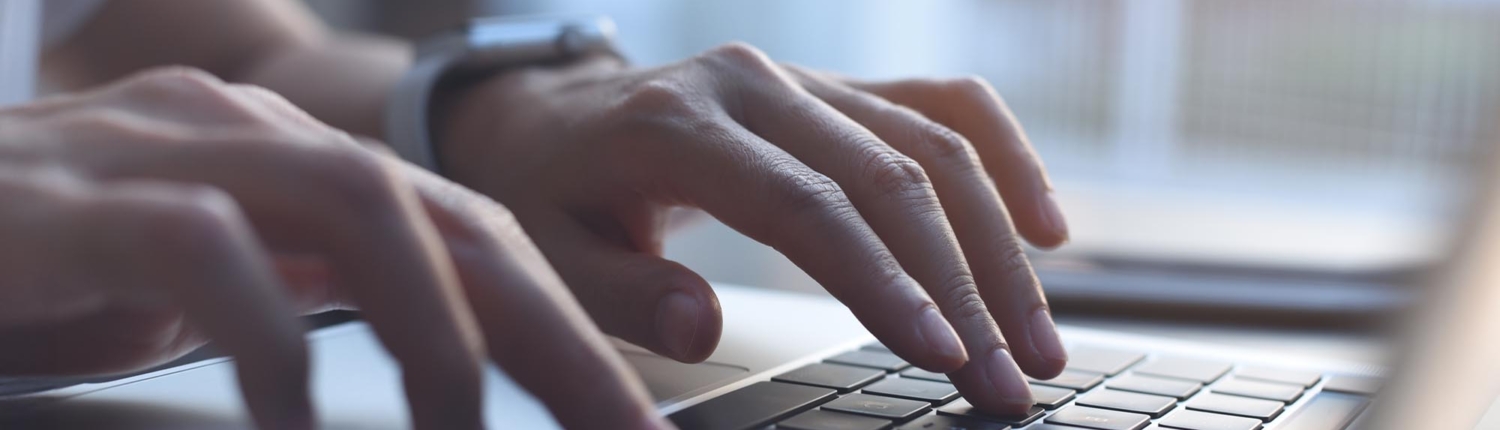 Close up of someone's hands while they're typing on a computer