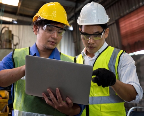Two manufacturing workers looking at computer