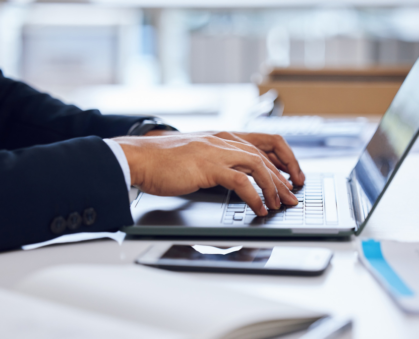 Side view of a businessman typing on laptop computer